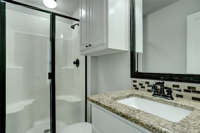 bathroom featuring toilet, tasteful backsplash, a shower with shower door, and oversized vanity