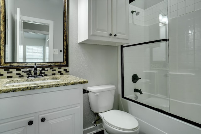 full bathroom featuring combined bath / shower with glass door, toilet, tasteful backsplash, and vanity