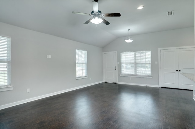 spare room featuring lofted ceiling, a healthy amount of sunlight, dark wood-type flooring, and ceiling fan