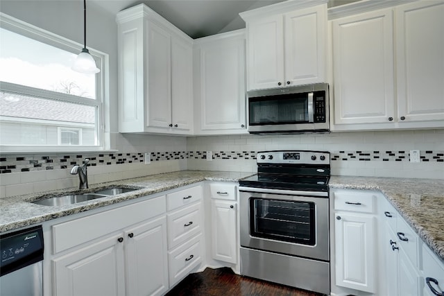 kitchen featuring appliances with stainless steel finishes, white cabinetry, tasteful backsplash, and sink