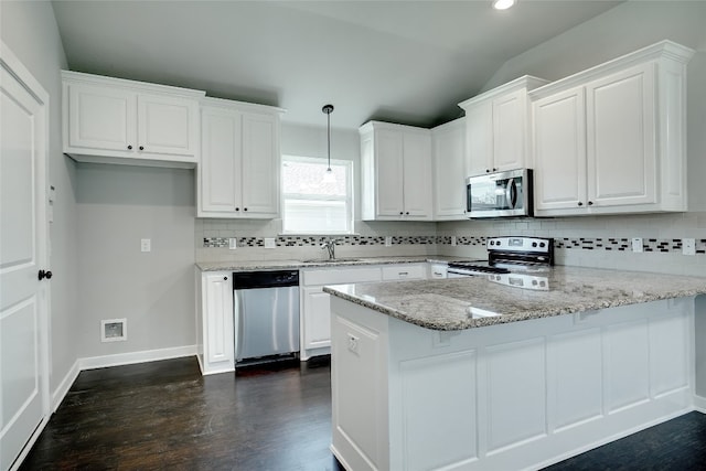 kitchen with backsplash, stainless steel appliances, white cabinetry, and dark hardwood / wood-style flooring