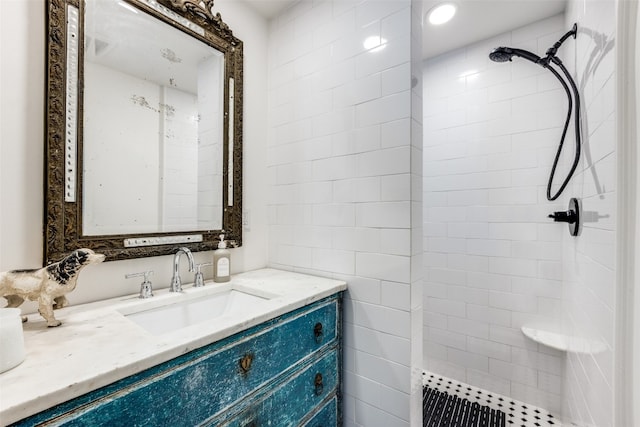 bathroom with tiled shower and vanity