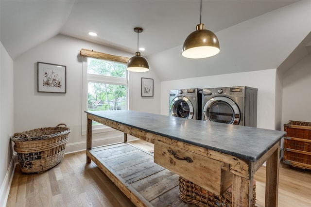 interior space featuring vaulted ceiling, hardwood / wood-style flooring, pendant lighting, and washer and clothes dryer