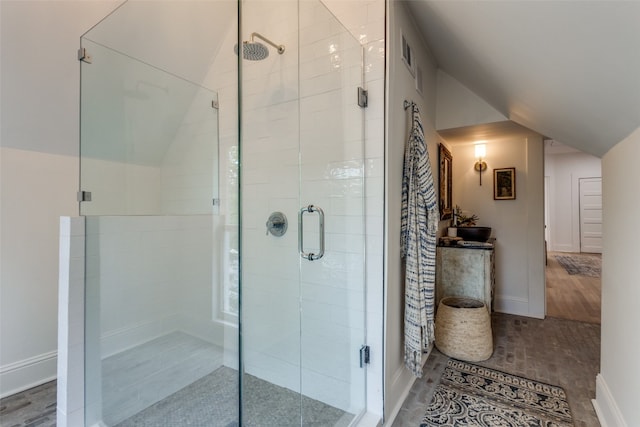 bathroom featuring a shower with shower door, tile flooring, and lofted ceiling