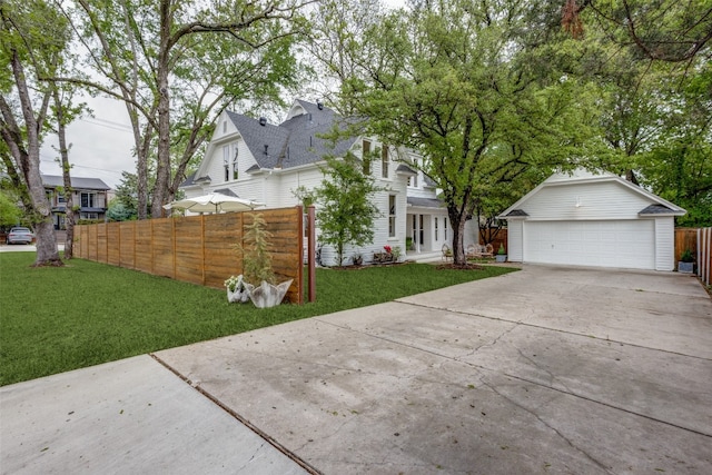 view of front of home featuring an outdoor structure, a garage, and a front yard