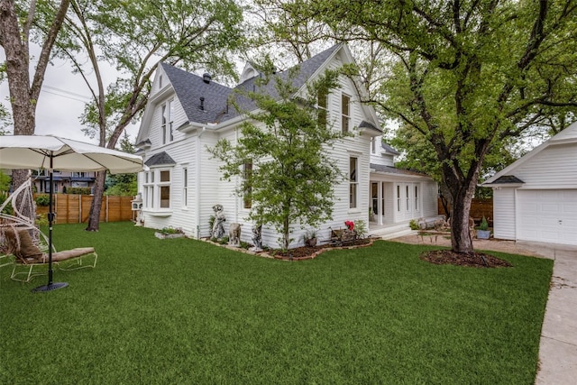 back of property featuring a garage and a yard