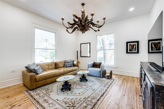 living room with light hardwood / wood-style flooring and a notable chandelier