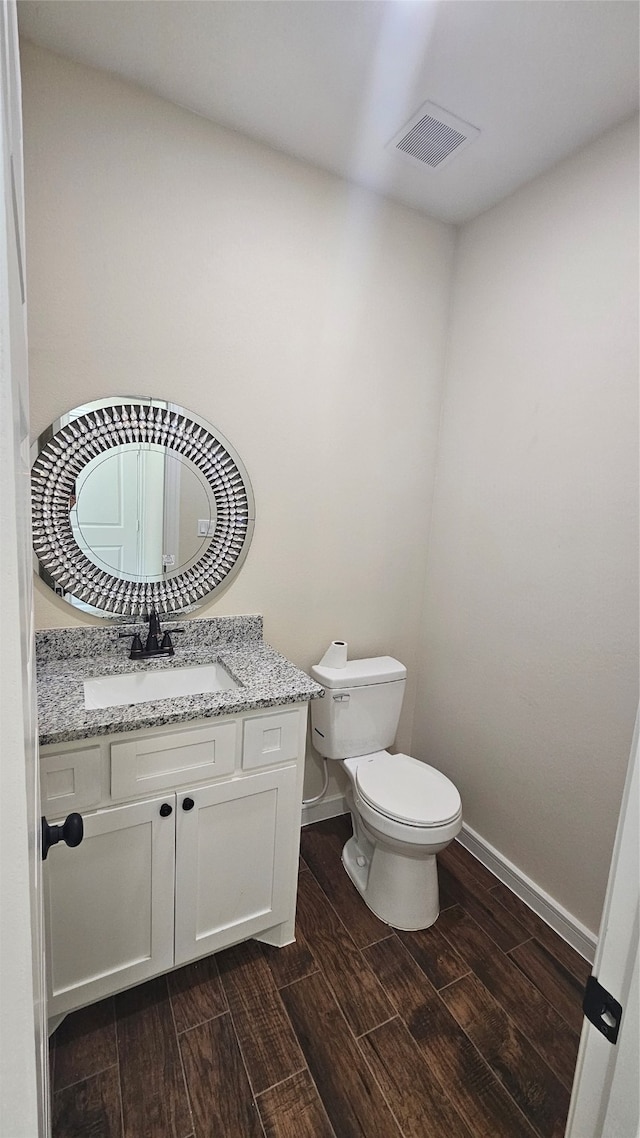 bathroom featuring wood-type flooring, vanity, and toilet