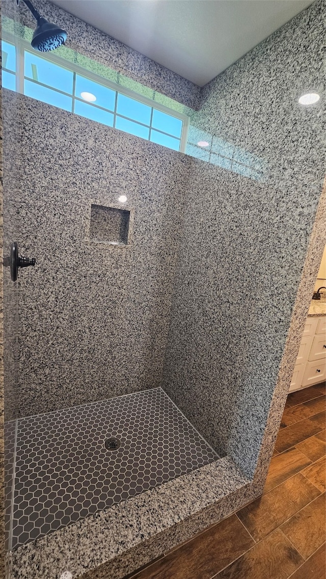 bathroom featuring hardwood / wood-style flooring and tiled shower