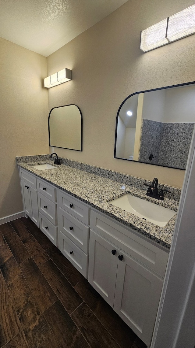 bathroom with hardwood / wood-style flooring, vanity, and a textured ceiling