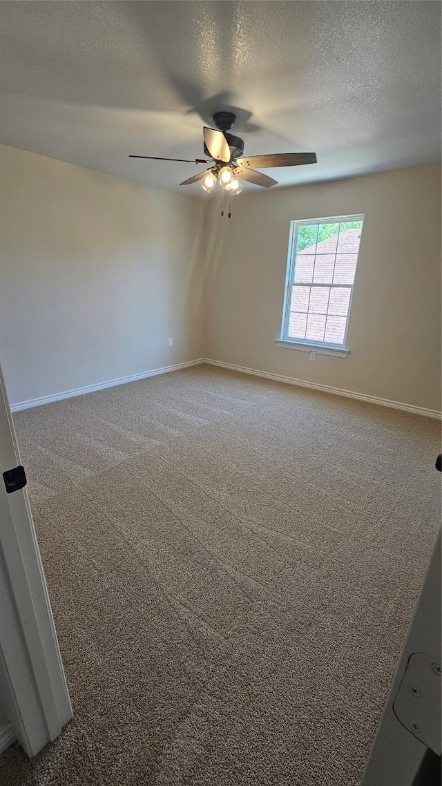 carpeted spare room featuring ceiling fan and a textured ceiling