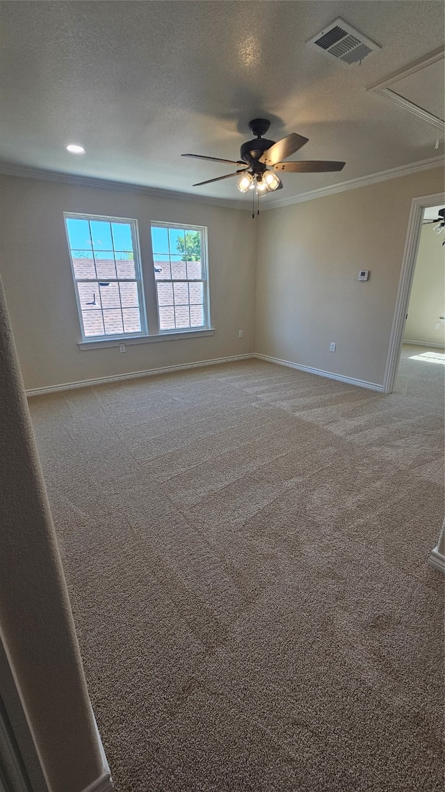 carpeted empty room featuring ceiling fan, a textured ceiling, and ornamental molding