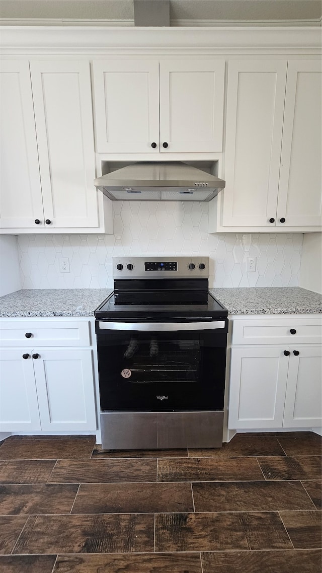 kitchen featuring wall chimney exhaust hood, white cabinetry, dark hardwood / wood-style floors, and electric range