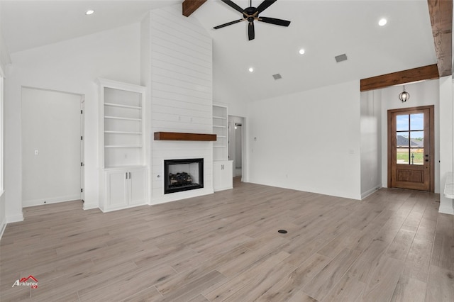 unfurnished living room with beamed ceiling, high vaulted ceiling, light hardwood / wood-style flooring, ceiling fan, and a large fireplace