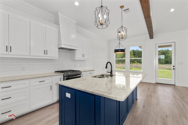 kitchen featuring light hardwood / wood-style floors, white cabinetry, stainless steel gas range, custom range hood, and sink