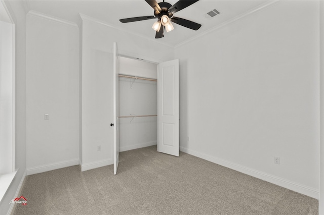 unfurnished bedroom with a closet, light carpet, crown molding, and ceiling fan