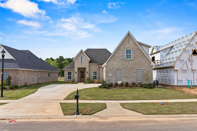 view of front of home with central AC unit and a front lawn