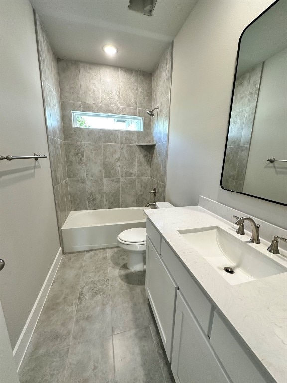 full bathroom featuring tile floors, toilet, tiled shower / bath, and vanity with extensive cabinet space