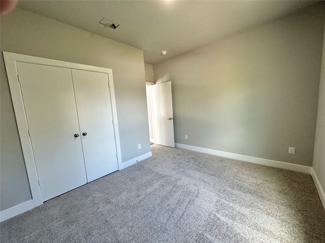 unfurnished bedroom with light carpet and a closet