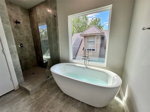 bathroom featuring tile flooring and separate shower and tub