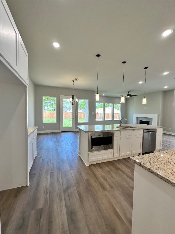 kitchen featuring light stone counters, stainless steel appliances, hardwood / wood-style flooring, and white cabinetry