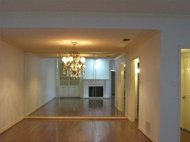 interior space with an inviting chandelier, dark hardwood / wood-style floors, and ornamental molding