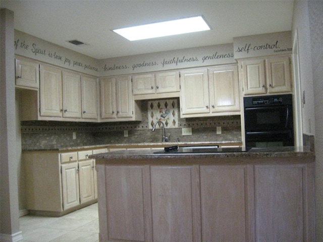 kitchen with black double oven, sink, tasteful backsplash, and light tile floors