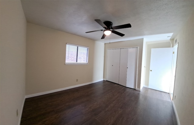 unfurnished bedroom with dark hardwood / wood-style floors, a closet, and ceiling fan