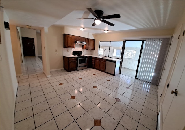 kitchen featuring tasteful backsplash, light tile floors, stainless steel appliances, ceiling fan, and sink