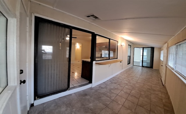 interior space featuring light tile floors and lofted ceiling