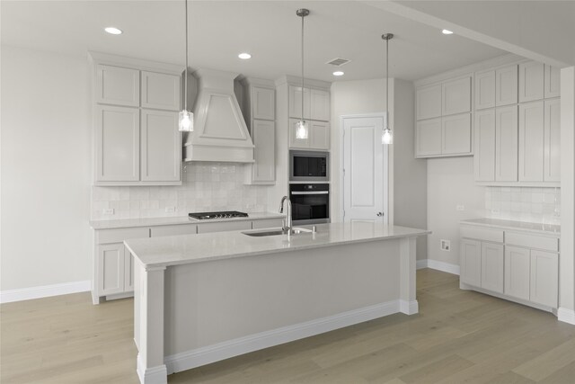 kitchen featuring light wood-type flooring, stainless steel appliances, backsplash, sink, and custom exhaust hood