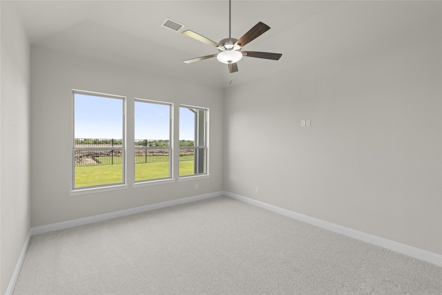 spare room with carpet flooring, vaulted ceiling, and ceiling fan