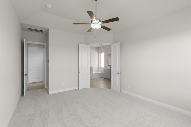 unfurnished bedroom with ceiling fan, lofted ceiling, connected bathroom, and light carpet