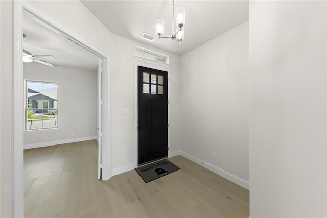 foyer entrance featuring ceiling fan with notable chandelier and hardwood / wood-style floors