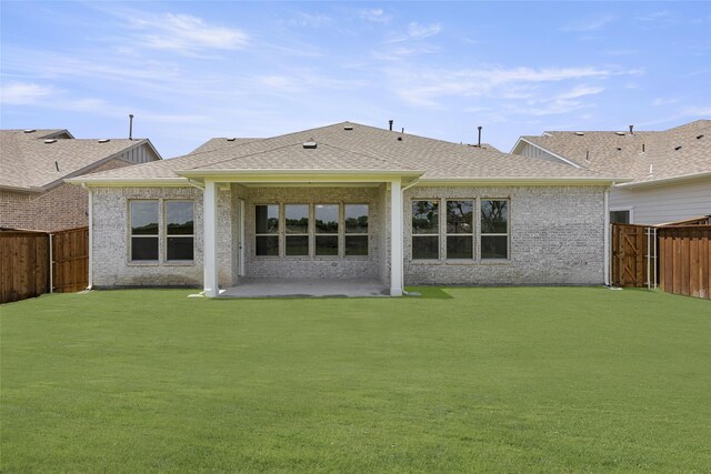 rear view of house featuring a patio area and a yard