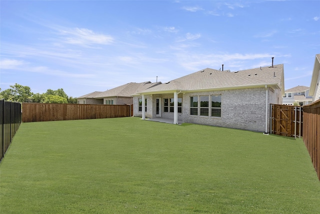 rear view of property featuring a patio area and a lawn