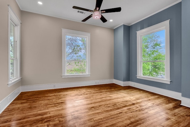 empty room with ceiling fan, plenty of natural light, and light hardwood / wood-style floors