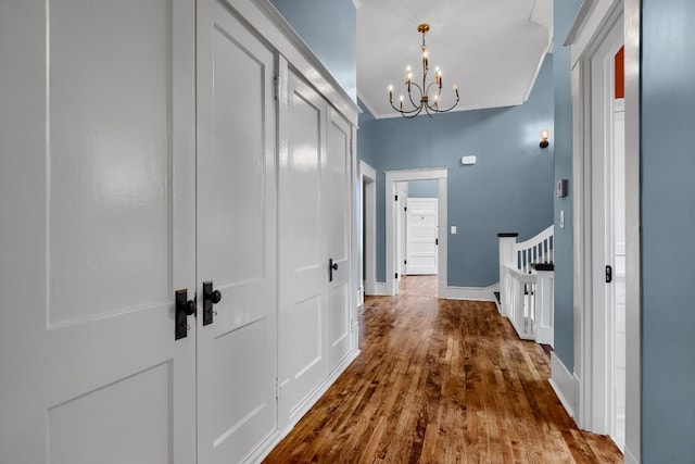 hallway with a chandelier and wood-type flooring