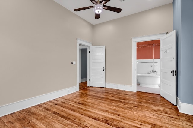 unfurnished bedroom with a high ceiling, a closet, ceiling fan, and light hardwood / wood-style flooring