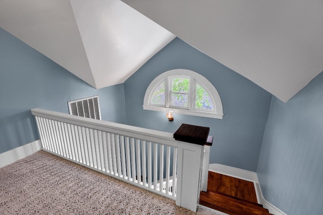 interior space with light carpet and vaulted ceiling