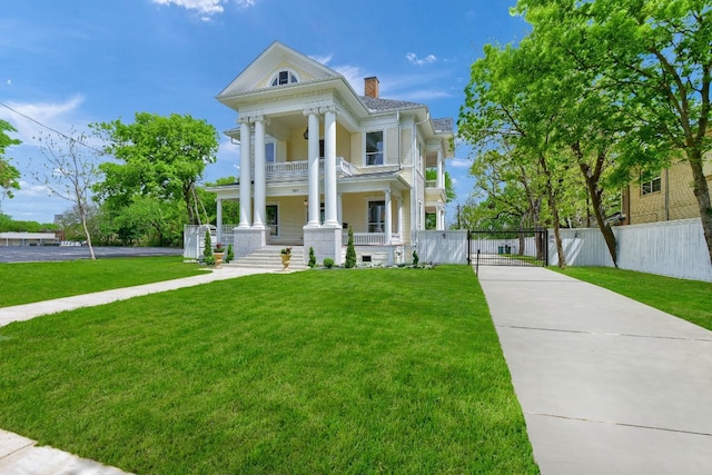 neoclassical home with covered porch and a front lawn