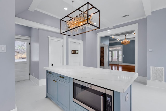 kitchen featuring decorative light fixtures, stainless steel microwave, and a healthy amount of sunlight