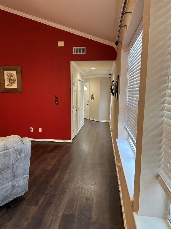 corridor featuring lofted ceiling, ornamental molding, and dark hardwood / wood-style floors