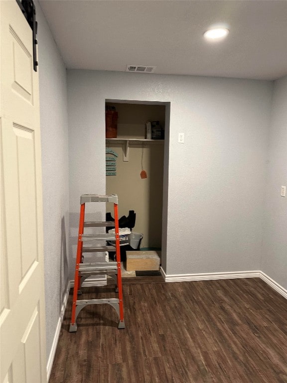 exercise area with a barn door and dark hardwood / wood-style flooring