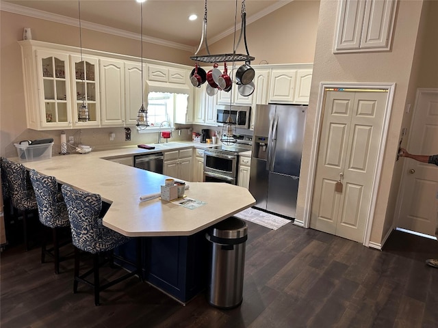 kitchen featuring white cabinetry, dark hardwood / wood-style floors, a kitchen breakfast bar, appliances with stainless steel finishes, and sink