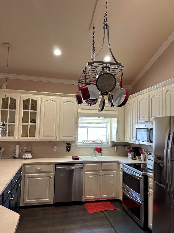 kitchen featuring sink, stainless steel appliances, white cabinetry, and vaulted ceiling