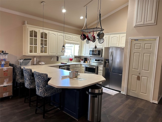 kitchen with kitchen peninsula, stainless steel appliances, vaulted ceiling, dark wood-type flooring, and white cabinetry