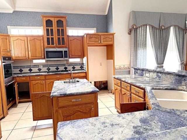 kitchen with an island with sink, tasteful backsplash, stainless steel appliances, and sink