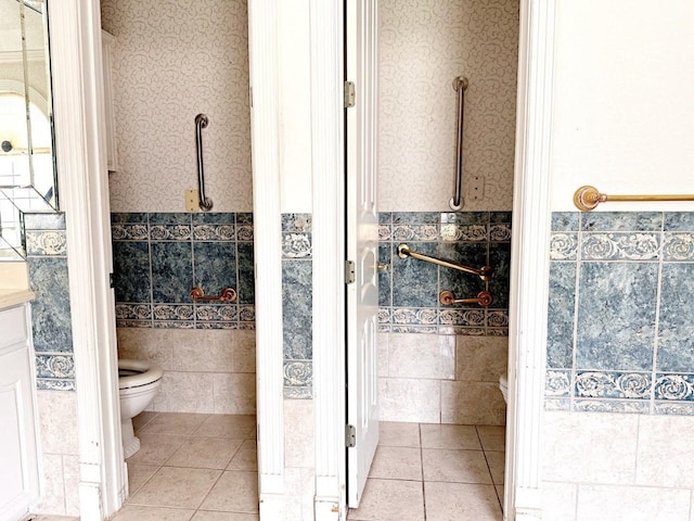 bathroom featuring vanity, tile flooring, toilet, and tile walls