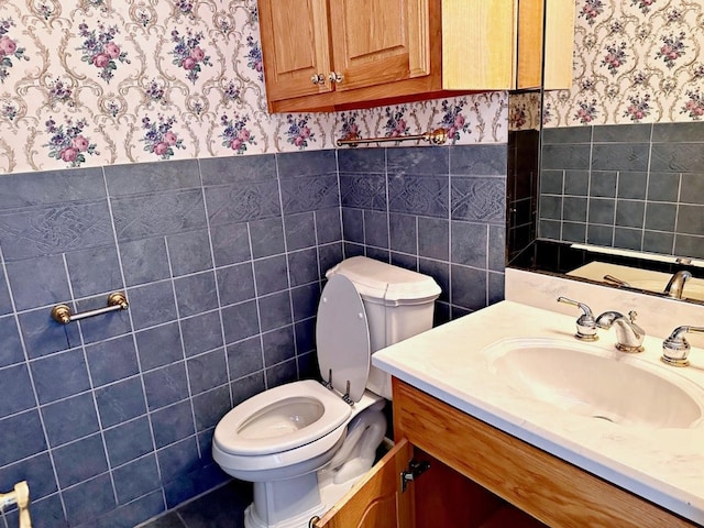 bathroom with tile walls, toilet, tile floors, and large vanity